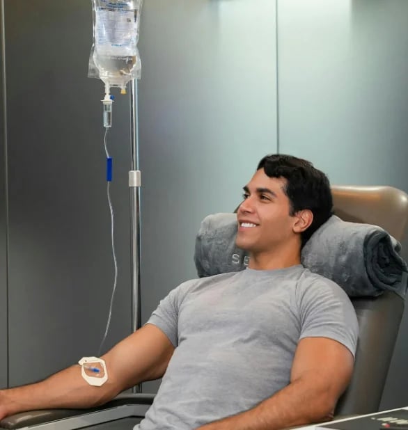 Man reclining in a treatment chair during an intravenous infusion