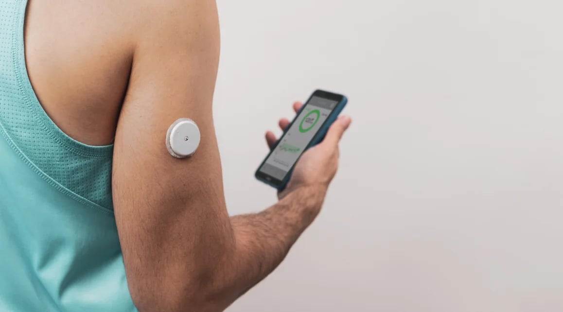 Continuous glucose monitor on the upper arm with a handheld reader