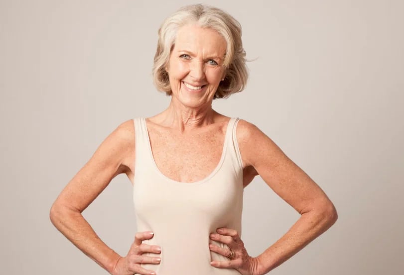Older woman standing with hands on hips, showing preserved muscle tone